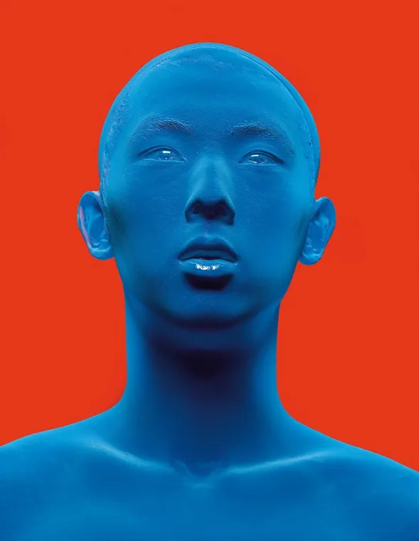Study of a man painted blue against a signal red field.